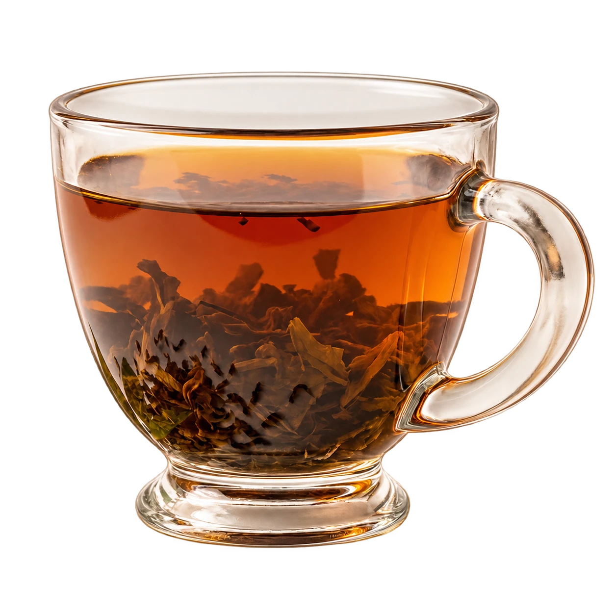 A clear glass of warm tea with tea leaves.